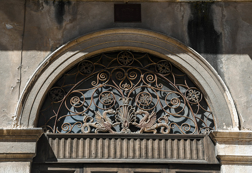Close-up of the overdoor of an old palace, decorated with a wrought iron bezel, Soave, Verona, Veneto, Italy