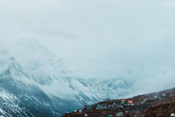 istock Clouds below the snow covered Himalayan mountains after the snowfall at Tinnan Valley in Lahaul Spiti district at Himachal Pradesh, India. Clouds under the snow covered mountains during the blizzard. 1452721187