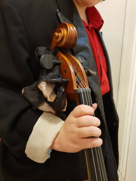Vertical shot of a man holding a violin