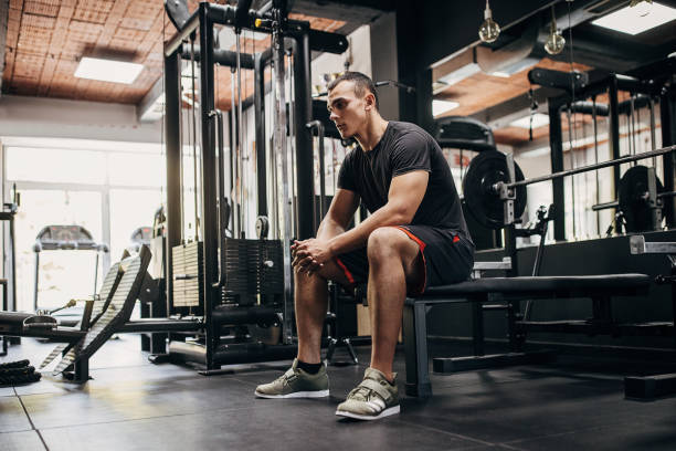 istock Young man sitting in gym 1452723995