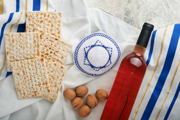 passover celebration concept. matzah, red kosher and walnut. traditional ritual jewish bread matzah, kippah and tallit on old concrete background. passover food. pesach jewish holiday. - passover seder wine matzo imagens e fotografias de stock