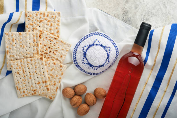 концепция празднования песаха. маца, красный кошерный и грецкий орех. традиционный ритуал еврейской хлебной мацы, кипы и таллита на старом � - passover matzo wine wine bottle стоковые фото и изображения