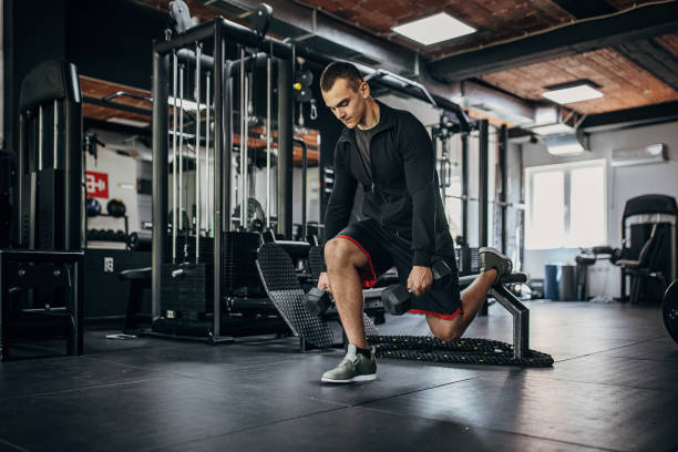 istock Young man exercising with dumbbells 1452724478
