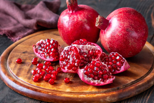 istock Fresh pomegranates on the wooden table 1452726933
