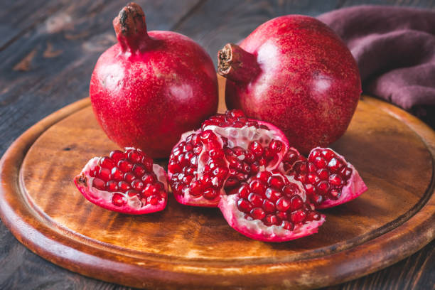 istock Fresh pomegranates on the wooden table 1452726943