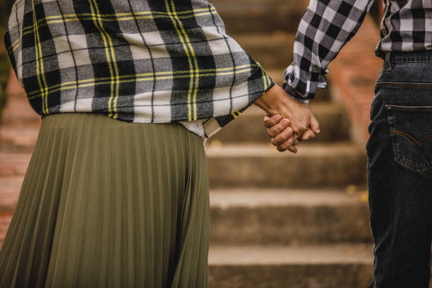 close up shot of unrecognizable senior couple holding hands and walking together - couple walking old middle imagens e fotografias de stock