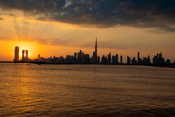 istock Dubai skyline during sunset. Dubai Downtown skyline panorama with reflections in Dubai Creek, gold colors, seen from Al Jaddaf walk Dubai. 1452729189