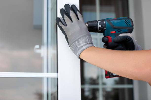 istock Worker's gloved hand holding an automatic screwdriver repairing a plastic door 1452731522