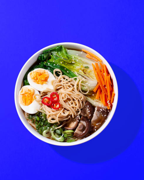 istock Ramen noodle soup with eggs, mushrooms, pak choi in hard light on orange 1452733241