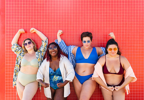 Group of beautiful plus size women with swimwear bonding and having fun at the beach - Group of curvy female friends enjoying summertime at the sea, concepts about body acceptance, body positive and self confidence