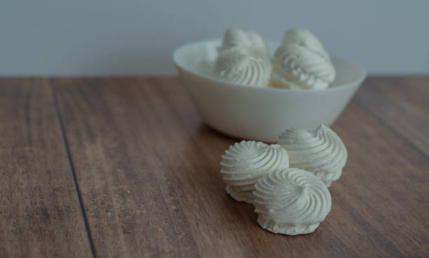 istock meringue in a white plate on a whitebackground and wooden surface 1452738412