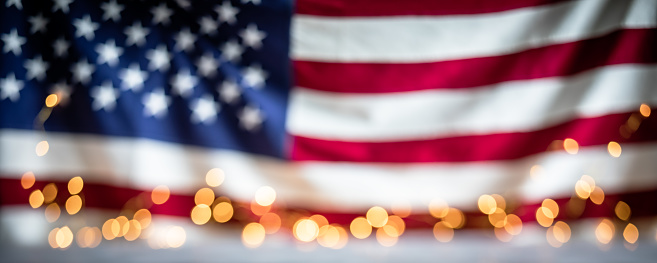 Defocused US flag with bokeh lights. Fourth of July Independence Day background.