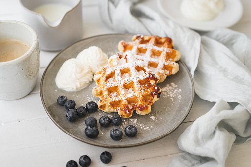 Heart shaped waffles over wooden table background