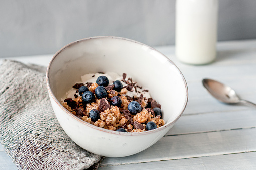 Granola with blueberries and chocolate in a bowl on a table