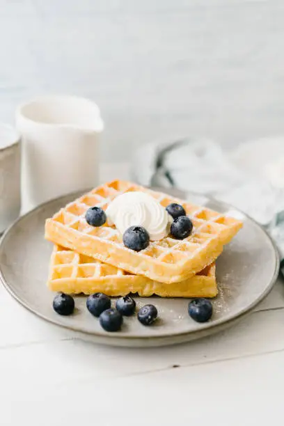 Waffles, berries and curd cheese on a wooden table