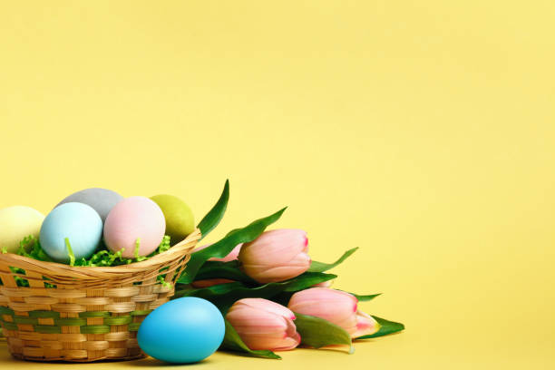 istock Basket with Easter eggs flowers tulips on the table. Close-up copy space still life 1452741981