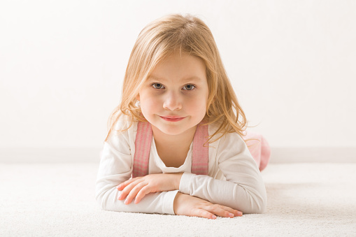 7 or 8 years old little girl with blond hair posing pointing with earrings