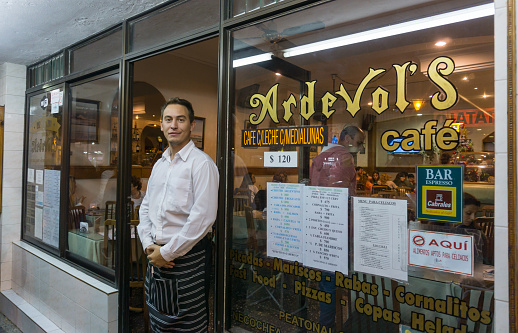 Necochea, Buenos Aires, Argentina. January 6, 2020. A waiter poses in front of Ardevol´s cafe in the night of Necochea