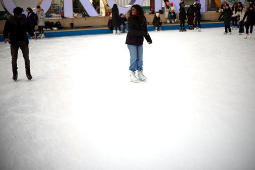 Toronto, Ontario, Canada- December 14th, 2022: A black lady ice skating at Toronto City Hall’s Nathan Phillips Square.