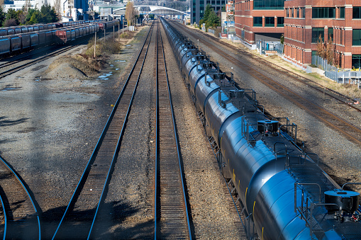 December 16, 2022 - A long line of black liquid container train cars on the Downtown Seattle train tracks.