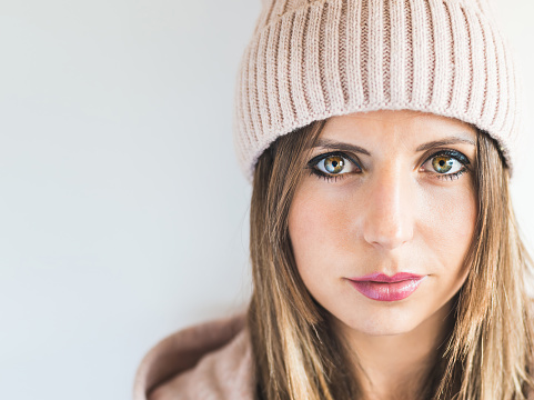 portrait of a Caucasian woman wearing a woolen cap and smiling. Looking at camera. natural light.