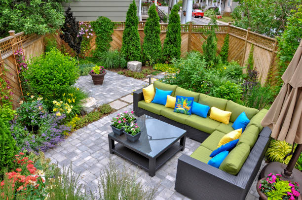 Small downtown Toronto urban back yard garden in summer. A beautiful small, urban backyard garden featuring a tumbled paver patio, flagstone stepping stones, and a variety of trees, shrubs and perennials add colour and year round interest. hardscape photos stock pictures, royalty-free photos & images
