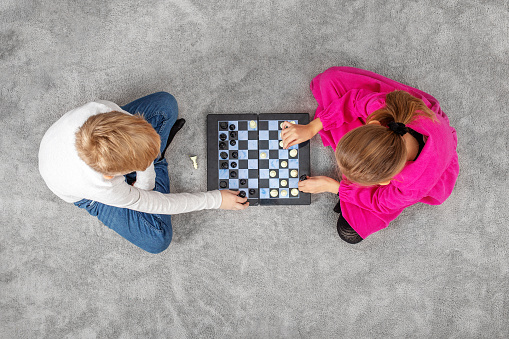 Children play a game of chess. Concept of family, hobby and leisure. Copy space