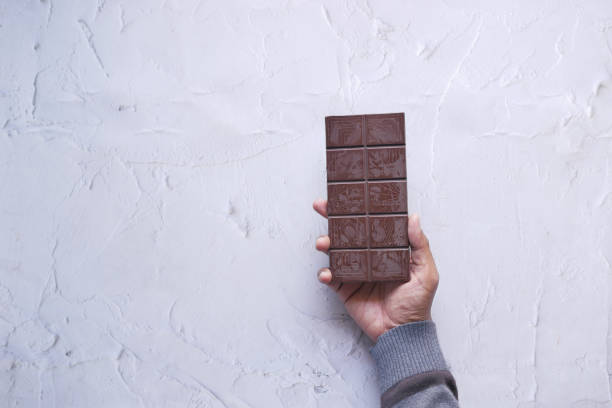 istock holding a dark chocolate on white background with copy space 1452755158