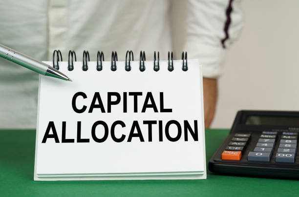 istock On a green surface, a calculator and a notepad with the inscription - capital allocation 1452757556