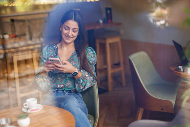 istock Young woman texting in coffee shop 1452761207