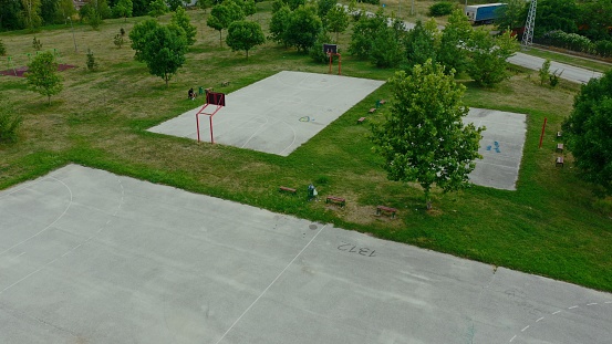 A drone shot of a playground in a residential neighborhood with green wide spaces in Serbia