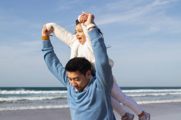 istock Happy Japanese family spending time on beach 1452768374