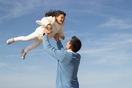 Happy father and daughter travelling together. Japanese family walking, laughing, fooling around, lifting child up. Dad leisure, family time, parenting bright