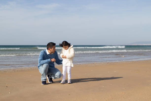 istock Asian family walking together on beach 1452769734