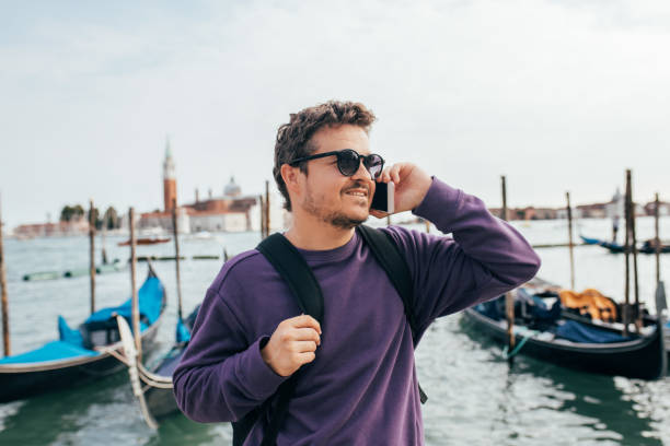 istock Handsome tourist with backpack talking on the phone in venice 1452770512