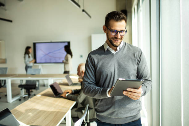 istock Confident young man businessman working inside modern office on a digital tablet 1452771755
