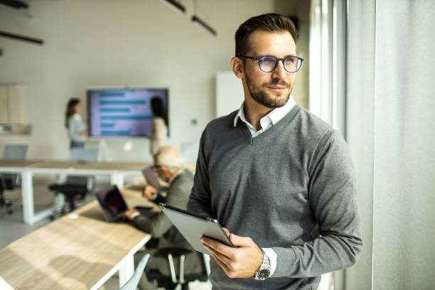istock Confident young man businessman working inside modern office on a digital tablet 1452771894