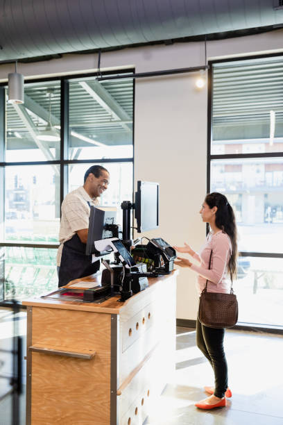 istock Female customer standing at the grocery store register 1452774234