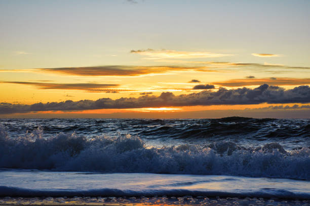 Stunning sunset over the sea. View from a low angle right at the water’s surface and bright sun corona on the horizon