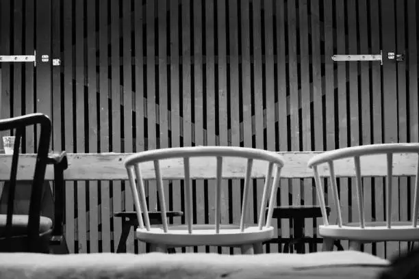 A black and white bar chairs in front of a barndoor wooden styled wall