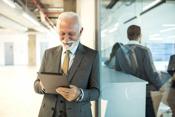 istock Confident senior man businessman working inside modern office on a digital tablet 1452778171