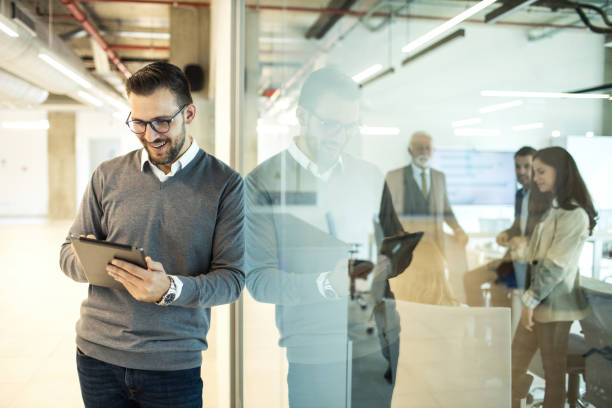 istock Confident young man businessman working inside modern office on a digital tablet 1452778471