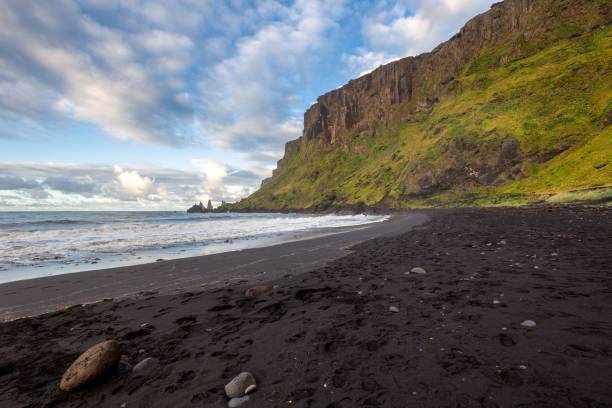 istock Sea waves approaching the black sand beach in Vik, Iceland under a cloudy sky 1452780187