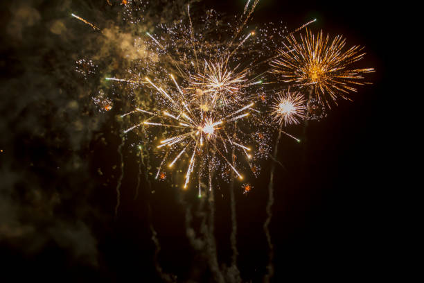 istock firework explosion from beautiful stars, splashes, sparks and bright lines of lights with smoke from red and yellow color against black sky 1452781262