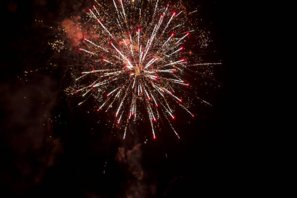 istock firework explosion from beautiful stars, splashes, sparks and bright lines of lights with smoke from red and yellow color against black sky 1452781272