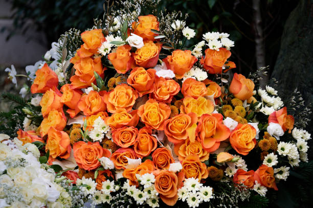 istock bouquet of orang colored roses on a grave 1452781923