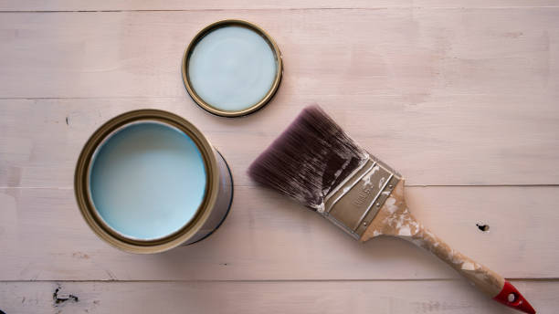istock Paint brush on paint can with partially painted timber surface in the background 1452784595