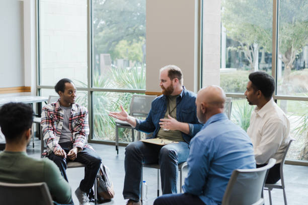 istock Male therapist gestures while advising man on his right 1452785806
