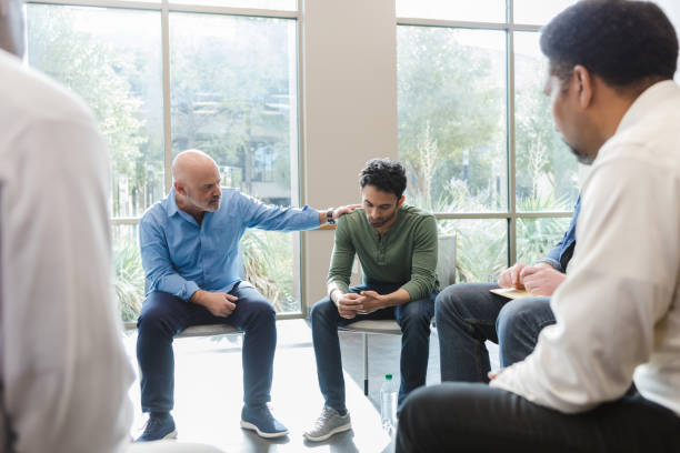 istock Mature man consoles friend in support group 1452785827