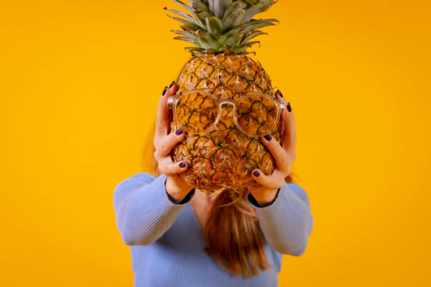 istock A pineapple in sunglasses in a studio on a yellow background, healthy, summer 1452787353
